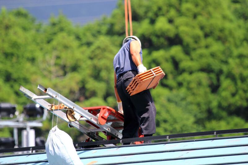 リフトで瓦を屋根に揚げる職人