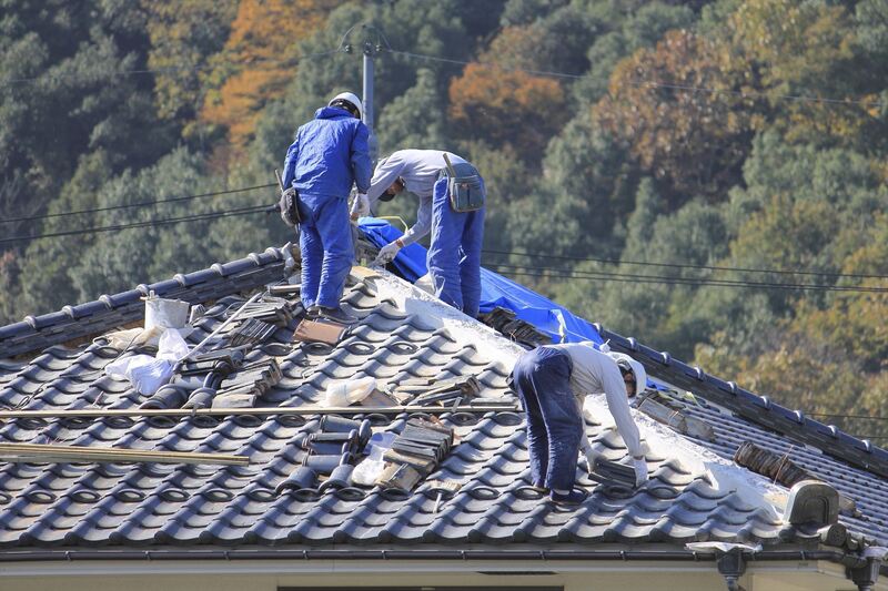 屋根瓦の補修工事を行うスタッフ_R
